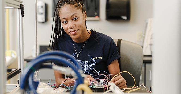 UA student in the engineering undergraduate program wires a circuit board.